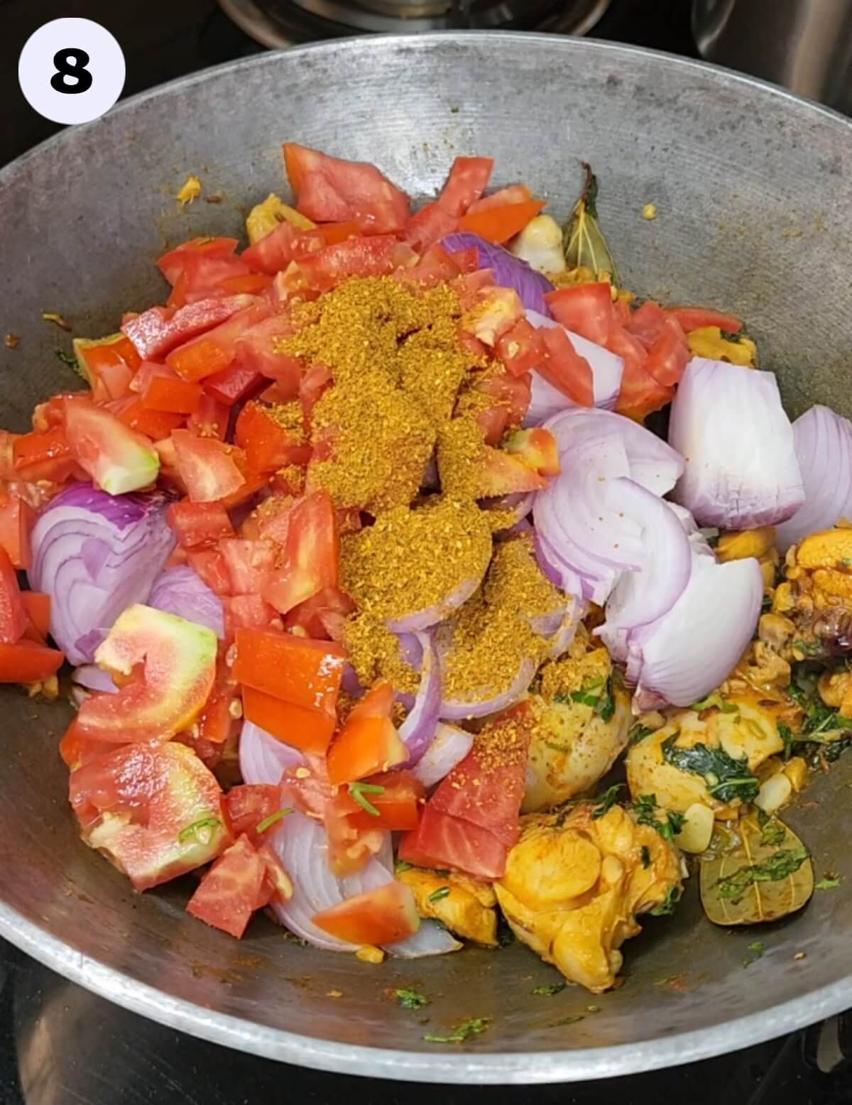 Onion, tomato, and tandoori masala powder added to a large pan/kadhai.