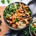 Mushroom noodle soup salad along with tofu and vegetables served in black bowls. Photo by Ella Olsson: https://www.pexels.com/photo/vegetable-salad-3026808/